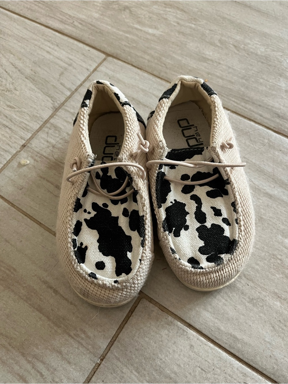 Hey Dude Kids Slip-On Sneakers in Cream with Black Cow Spot Print